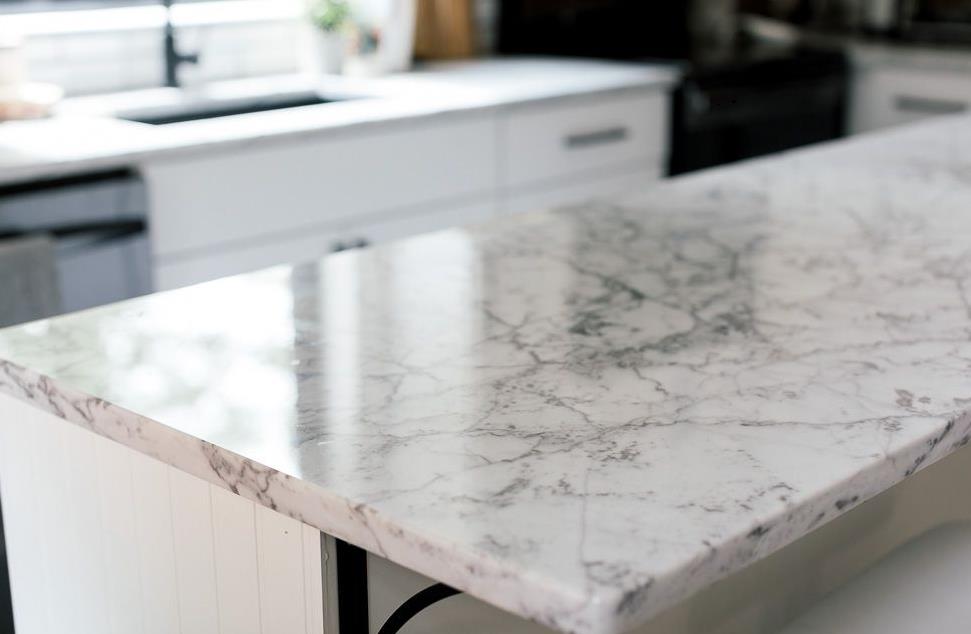 A modern kitchen countertop with marble pattern and stainless steel appliances
