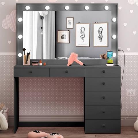A stylish makeup vanity with a mirror, lights, and various beauty products displayed on top.
