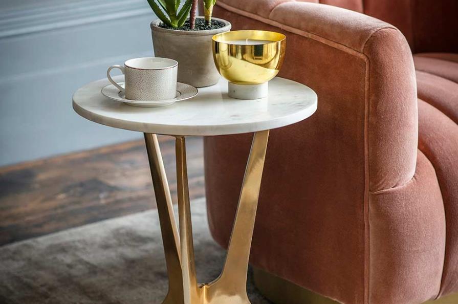 A white marble side table with gold accents and a modern design